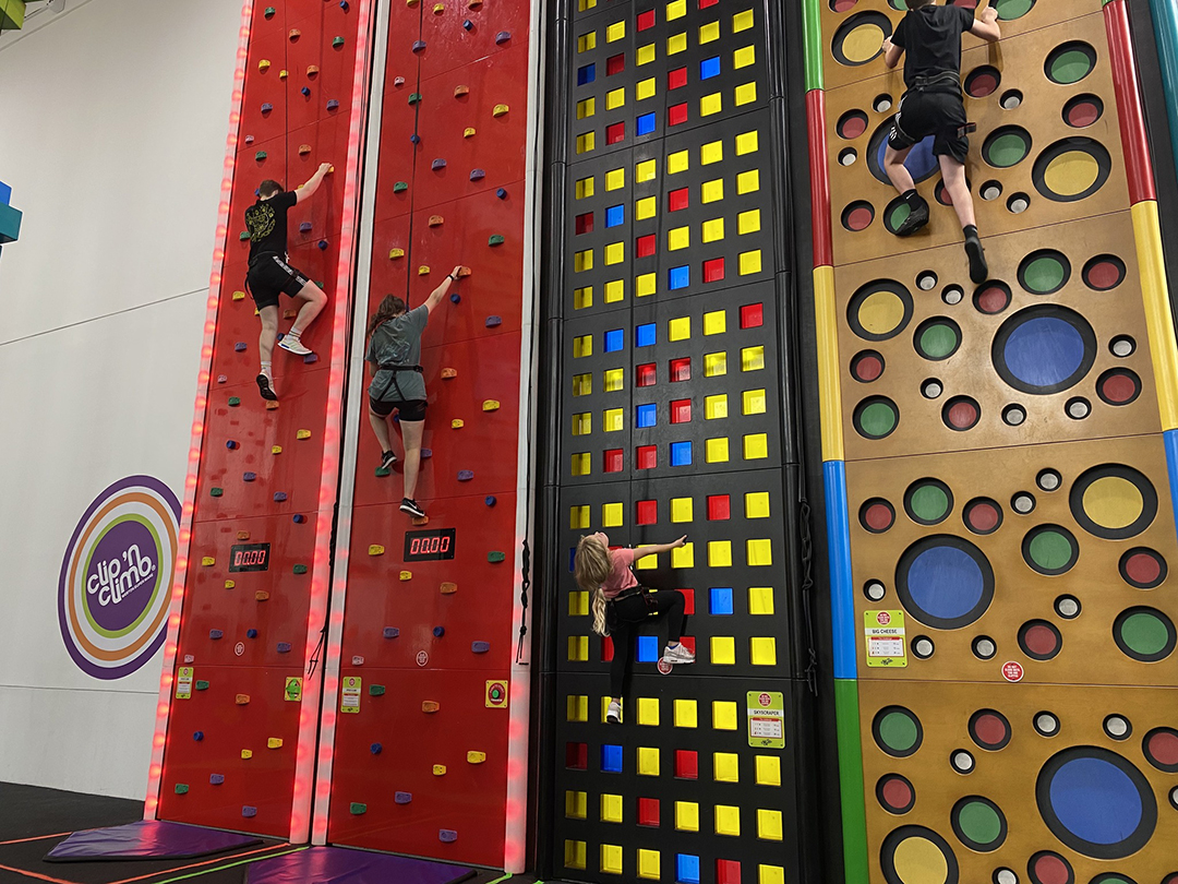 People climbing a brightly coloured climbing wall